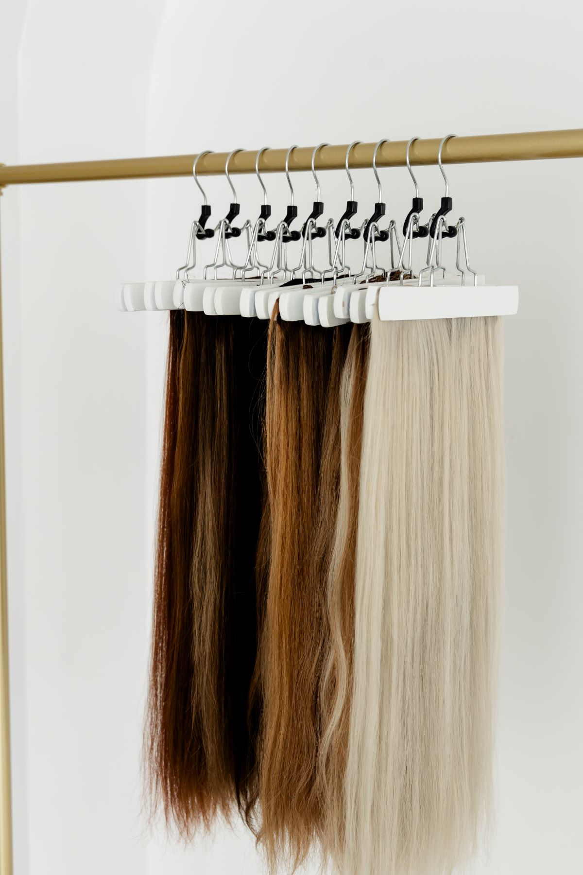 Hair extensions in various shades hanging on a rack in Raleigh, North Carolina.