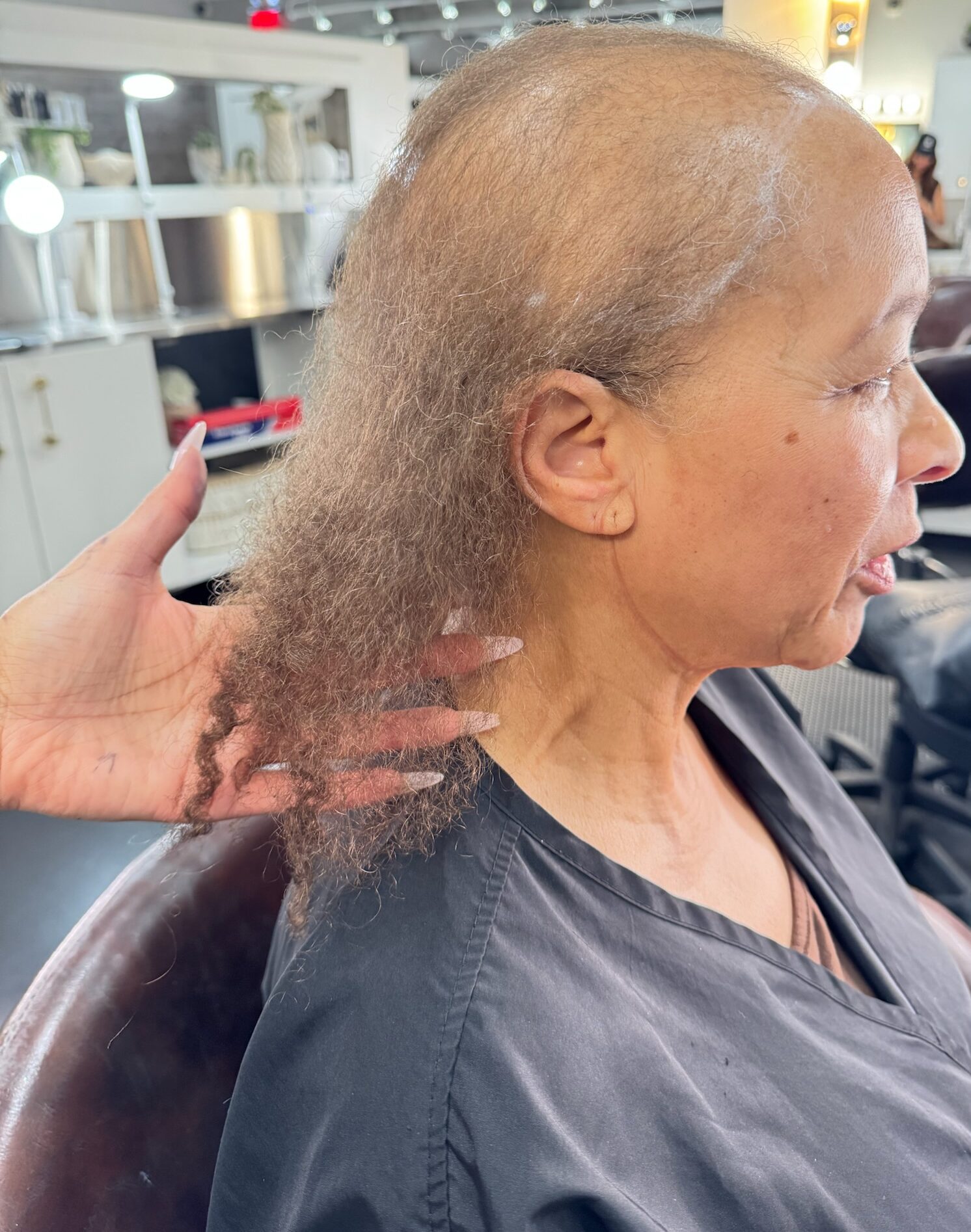 A Garnish stylist shows a guest's thinning hair pre-transformation