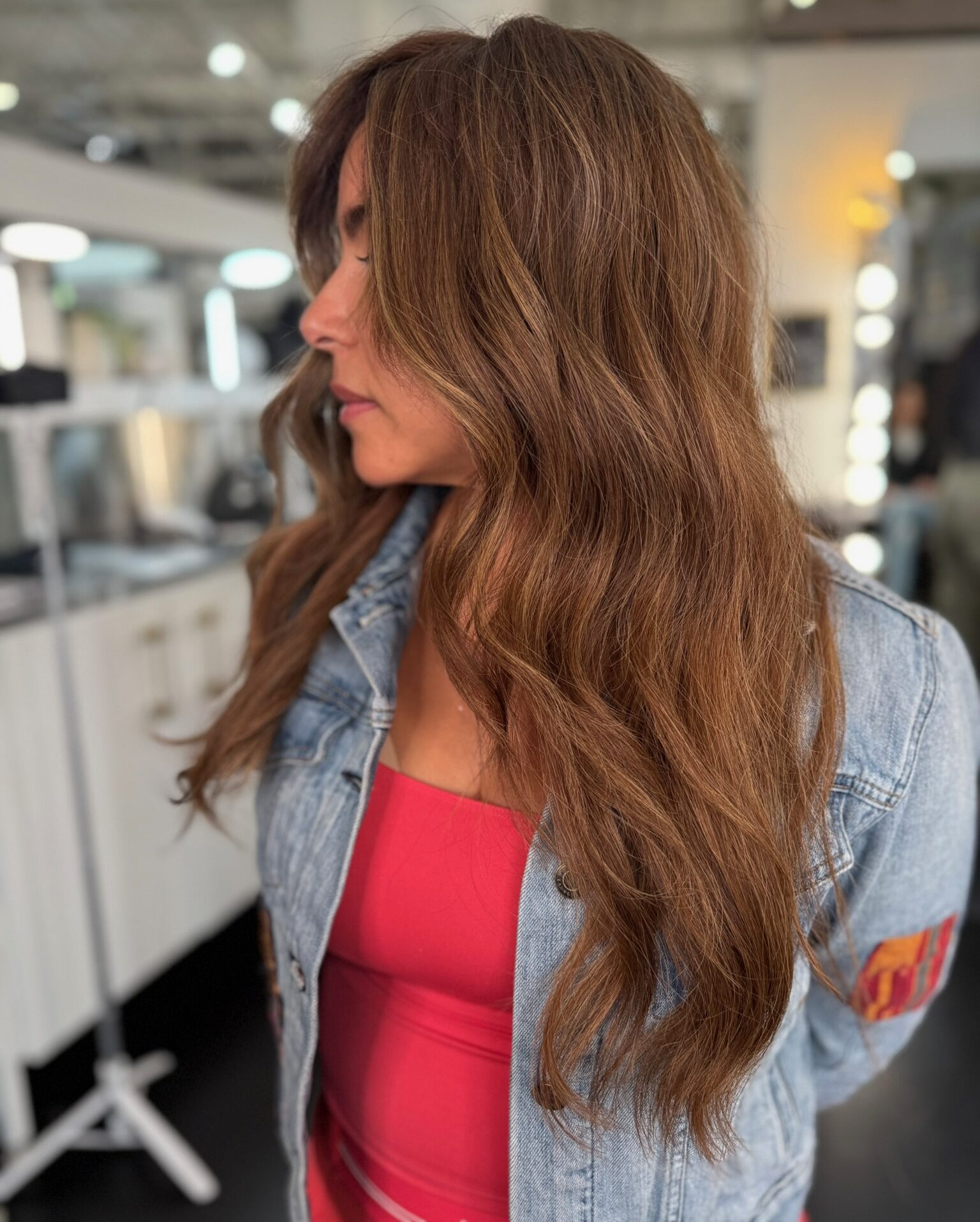 a Garnish guest shows off her new fall transition hair in caramel waves